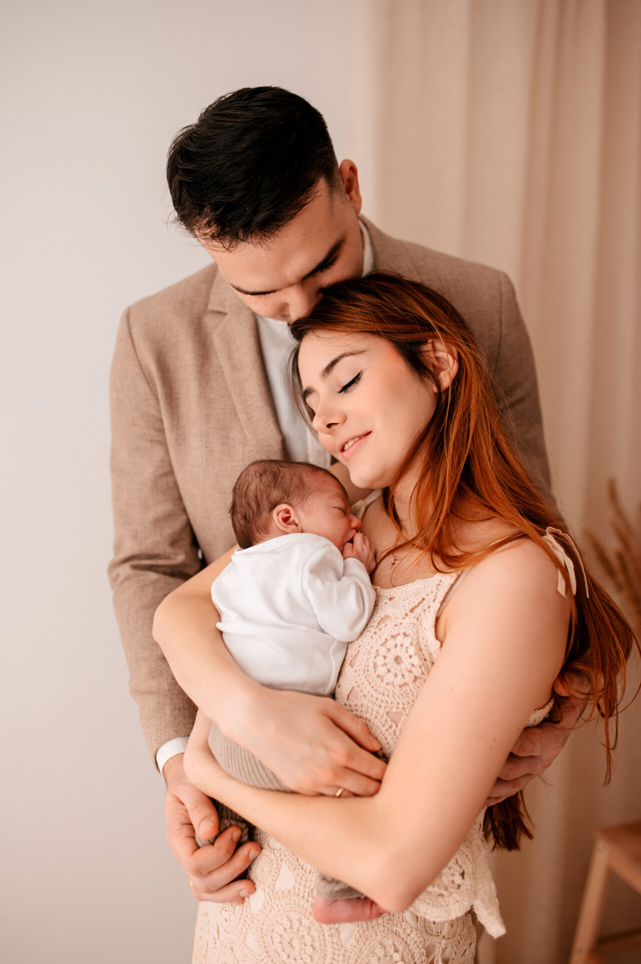 Mama tuląca noworodka podczas sesji w studio w Tuszynie koło Łodzi