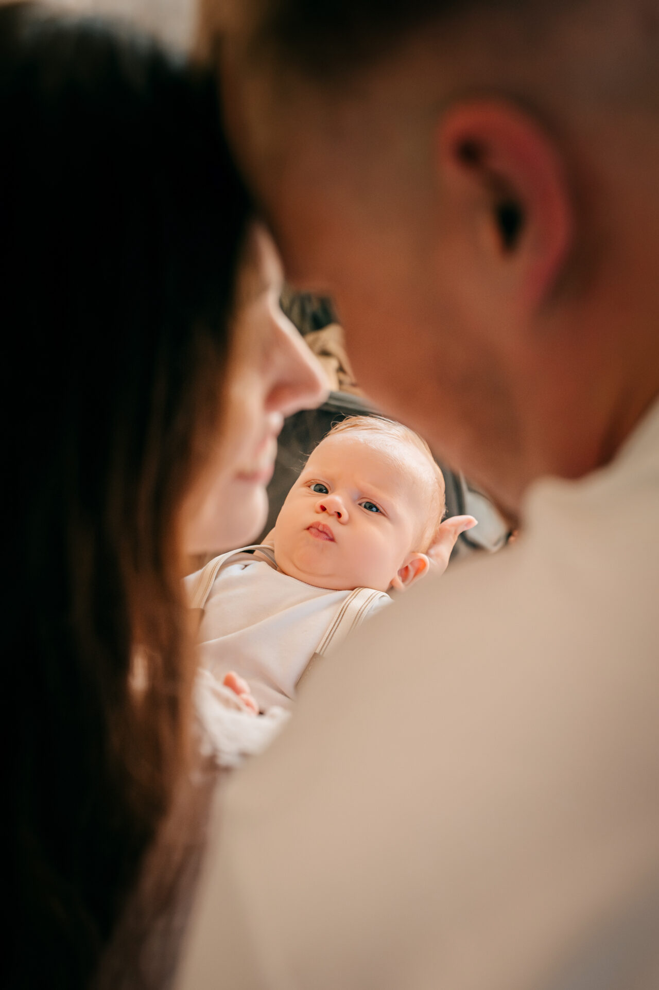 Rodzice tulą noworodka podczas domowej sesji – fotograf rodzinny Łódź